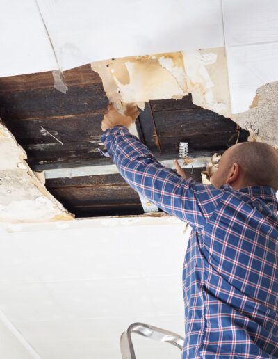 Man repairing collapsed ceiling.